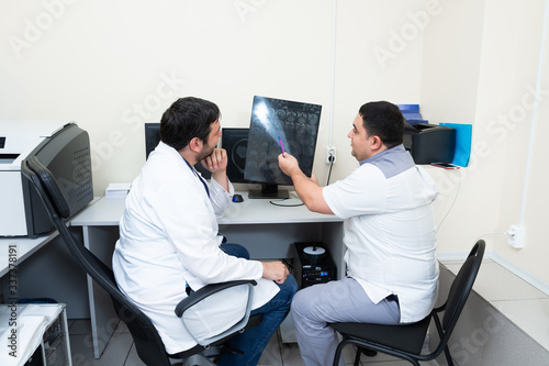 Twodoctors looking at patient's brain scanning.Medical consultation discuss MRI image