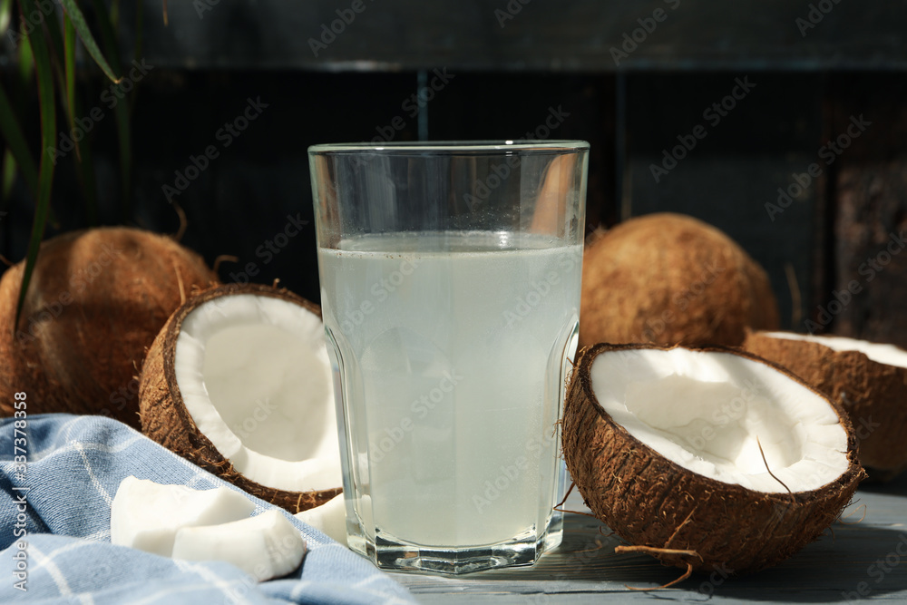 Coconut and water on wooden background, close up. Tropical fruit Coconut and water on wooden background, close up. Tropical fruit