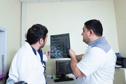 Twodoctors looking at patient's brain scanning.Medical consultation discuss MRI image