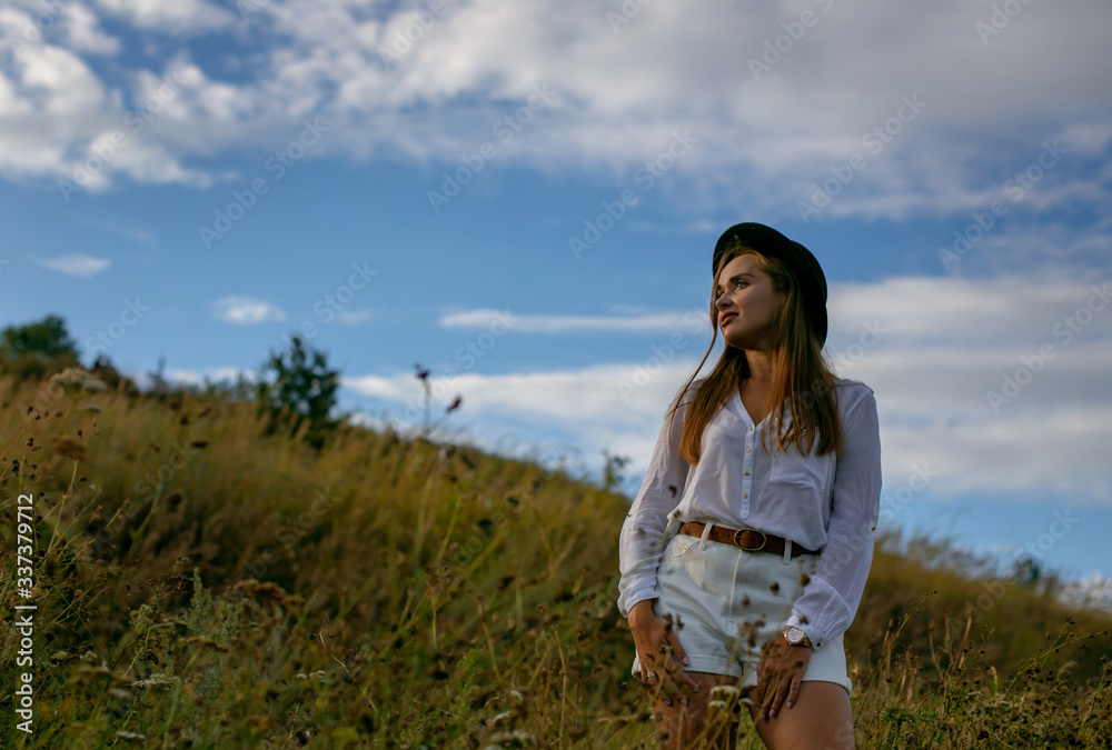 horizontal portrait of a beautiful blonde in white clothes on a background of nature and a cloudy sky horizontal portrait of a beautiful blonde in white clothes on a background of nature and a cloudy sky