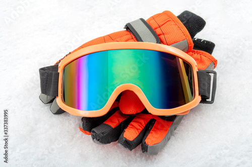 Obraz na płótnie Snowboarding and skiing protective gear and winter extreme sports concept with ski goggles and cold weather gloves isolated on white snow background w salonie