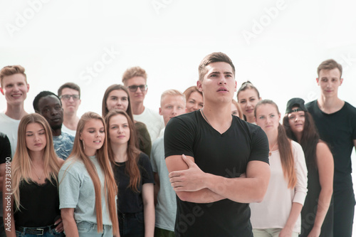 confident guy standing in front of a casual group of young people.