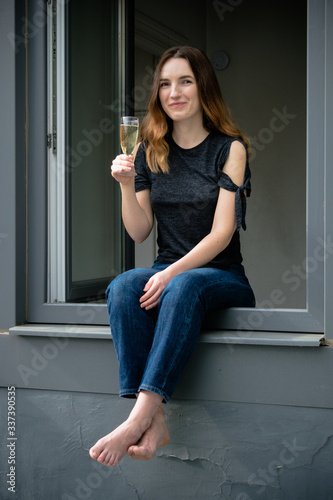 Beautiful and happy girl having a drink in the window 1
