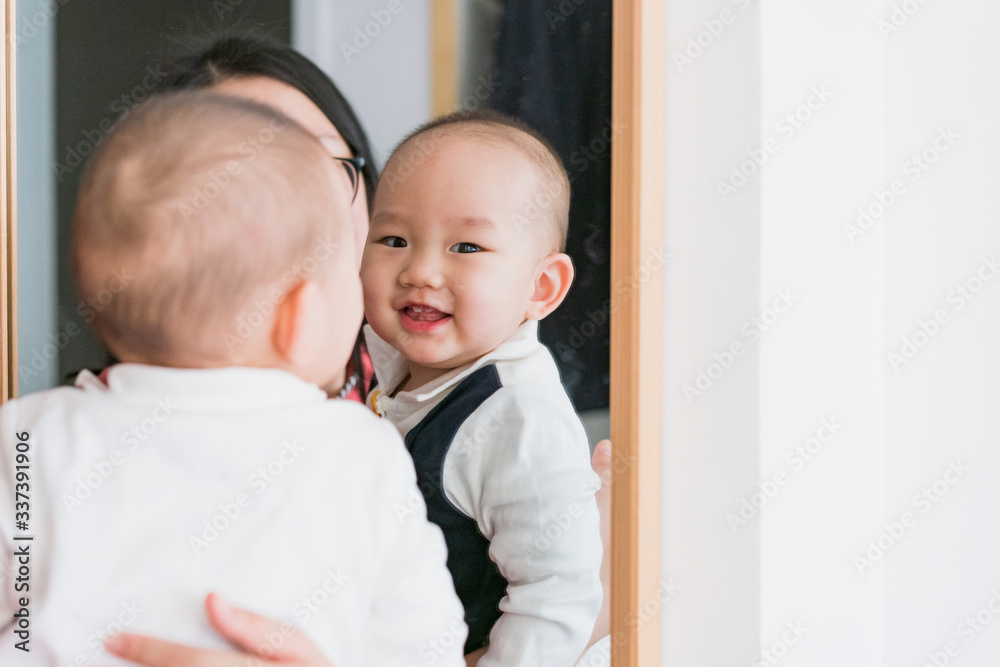 Baby playing in the bedroom in front of the mirror Baby playing in the bedroom in front of the mirror