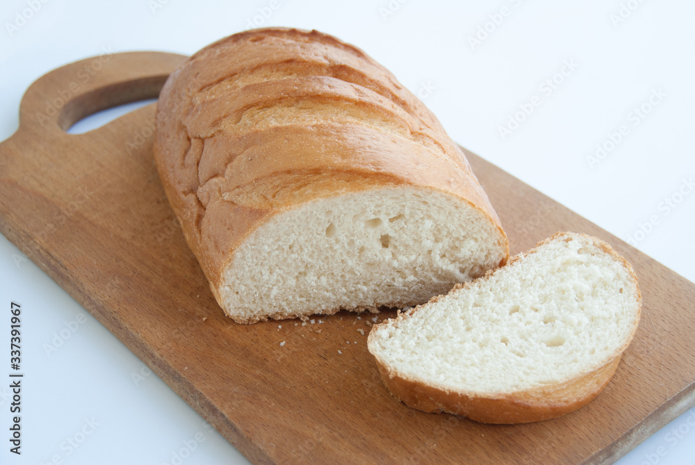 Sliced loaf of bread on a cutting board isolated on white background. Close up
