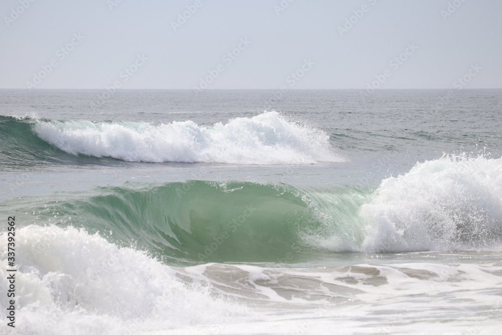 Fototapeta premium Zbliżenie curling fal oceanu w pobliżu plaży