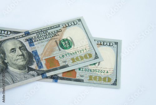 Hundred dollar banknotes lying on each other, isolated on white background