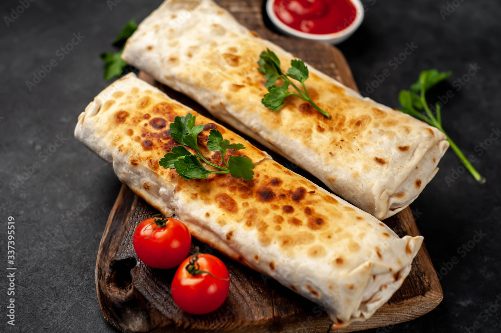 Burrito wraps with chicken and vegetables , against a background of concrete,
Mexican shawarma Burrito wraps with chicken and vegetables , against a background of concrete,
Mexican shawarma