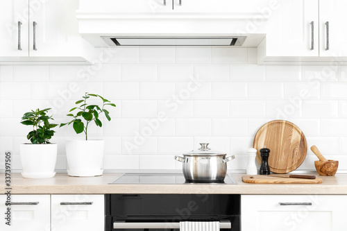 White modern kitchen interior with wooden worktop and kitchenware, culinary concept, background