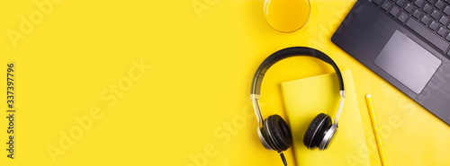 Online education or training concept, work online, top view. Work at home. Telecommuting. Laptop, books on a yellow background. Copy space