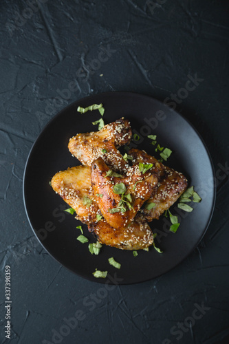 Crispy chicken wings with sesame seeds and chopped herbs