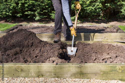 Man digging a hole with a shovel in a garden, UK photo