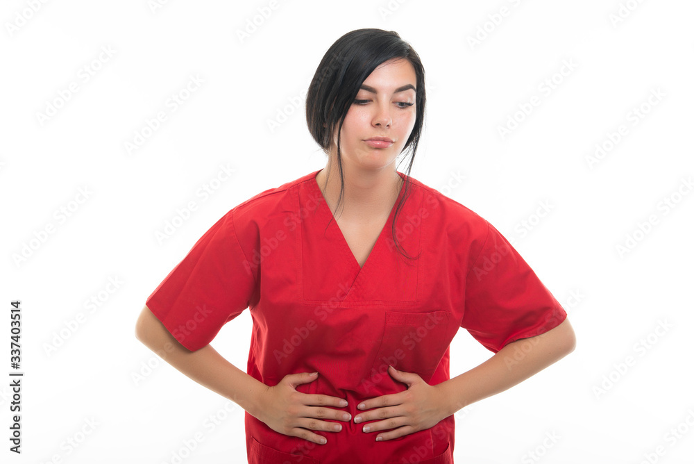 Portrait of young attractive female nurse holding stomach like hurting Portrait of young attractive female nurse holding stomach like hurting