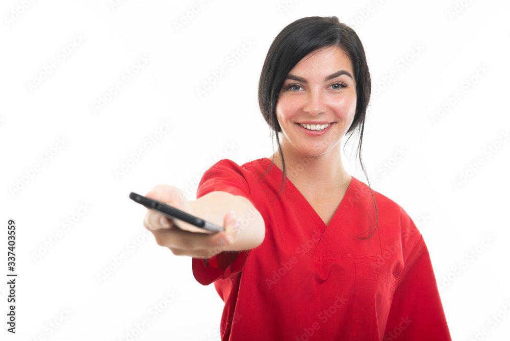 Portrait of young attractive female nurse handing telephone Portrait of young attractive female nurse handing telephone