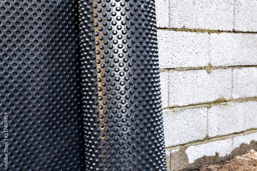 Φωτογραφία basement wall waterproofing - installing dimple geomembrane