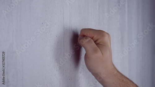 Male Knocks on a white wooden door with his hand. Debt and tax concept