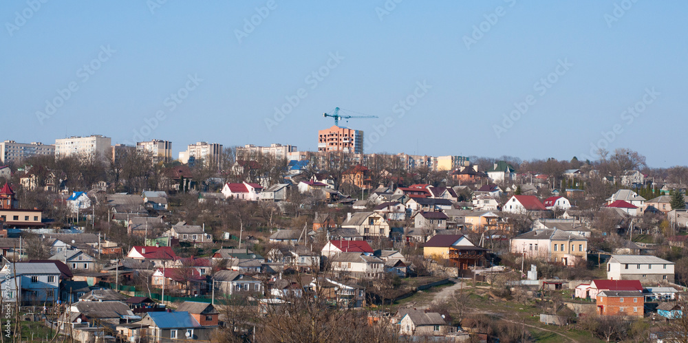 Panorama of the city. Construction crane. Many houses