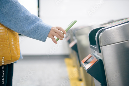 Young woman using smart phone to pay at metro station.