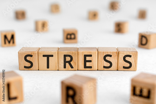 Stress - word from wooden blocks with letters, great worry caused by a difficult situation stress concept, random letters around white background