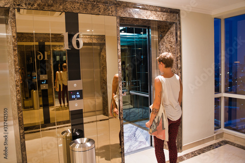 Blonde woman with short hair entering an elevator © carles