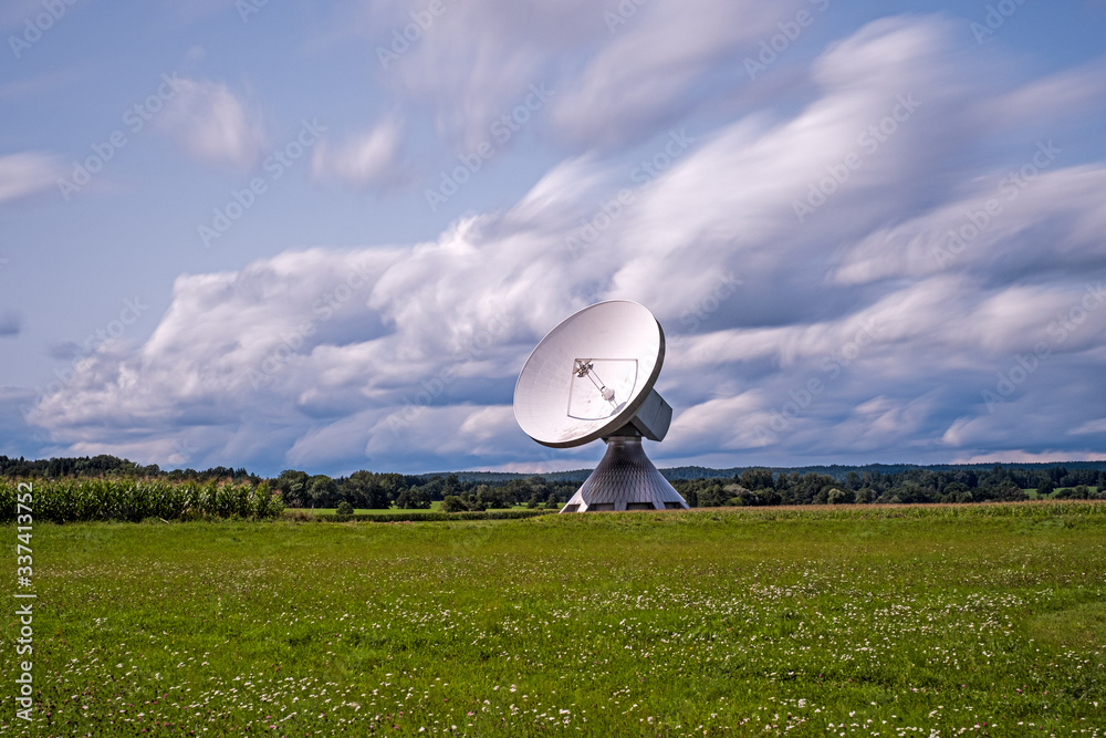 Huge parabolic antenna in the midst of a beautiful landscape