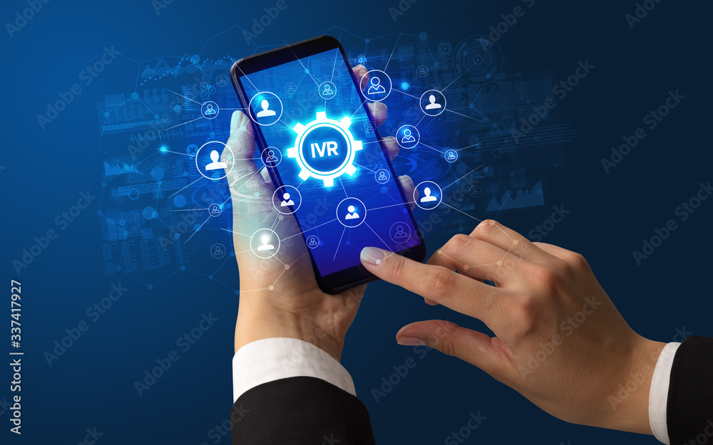 Female hand holding smartphone with IVR abbreviation, modern technology concept Female hand holding smartphone with IVR abbreviation, modern technology concept