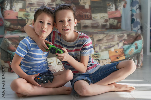 two little funny boys having lots of fun with video games