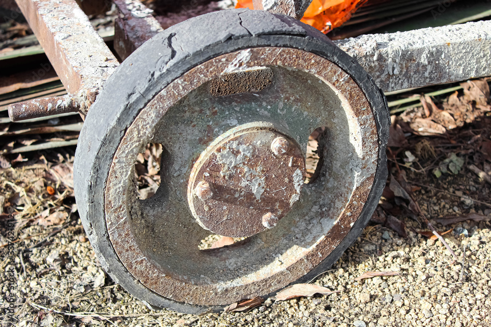 An old rusty wheel made of iron from a cart. An old rusty wheel made of iron from a cart.