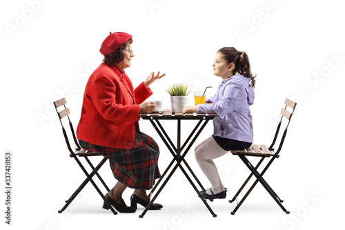 Grandmother and granddaughter sitting in a cafe and talking