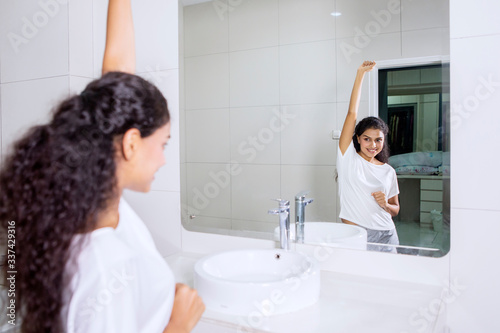 Pretty woman lifting her hand in bathroom