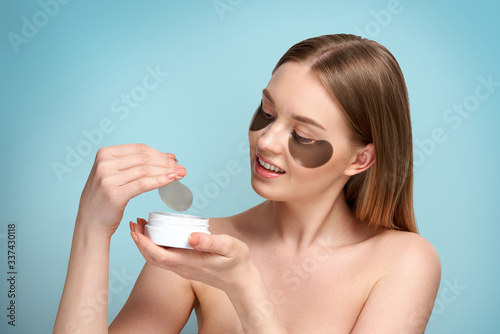 Fototapet Portrait of Beauty woman with eye patches showing an effect of perfect skin