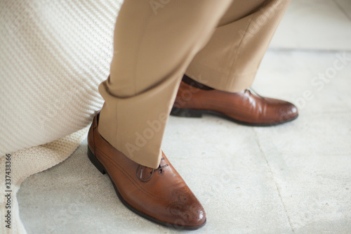 Brown shoes on the man and brown trousers.