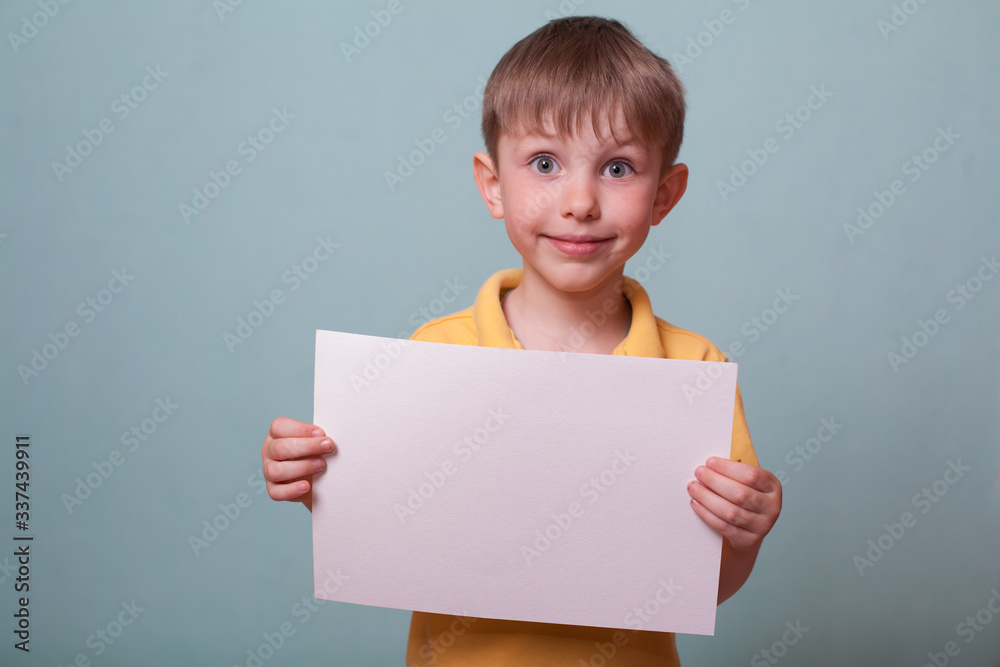 A beautiful child with big eyes in a yellow Polo shirt is holding a mocap and smiling. Concept education, child development, child care, Pediatrics. Place to copy A beautiful child with big eyes in a yellow Polo shirt is holding a mocap and smiling. Concept education, child development, child care, Pediatrics. Place to copy