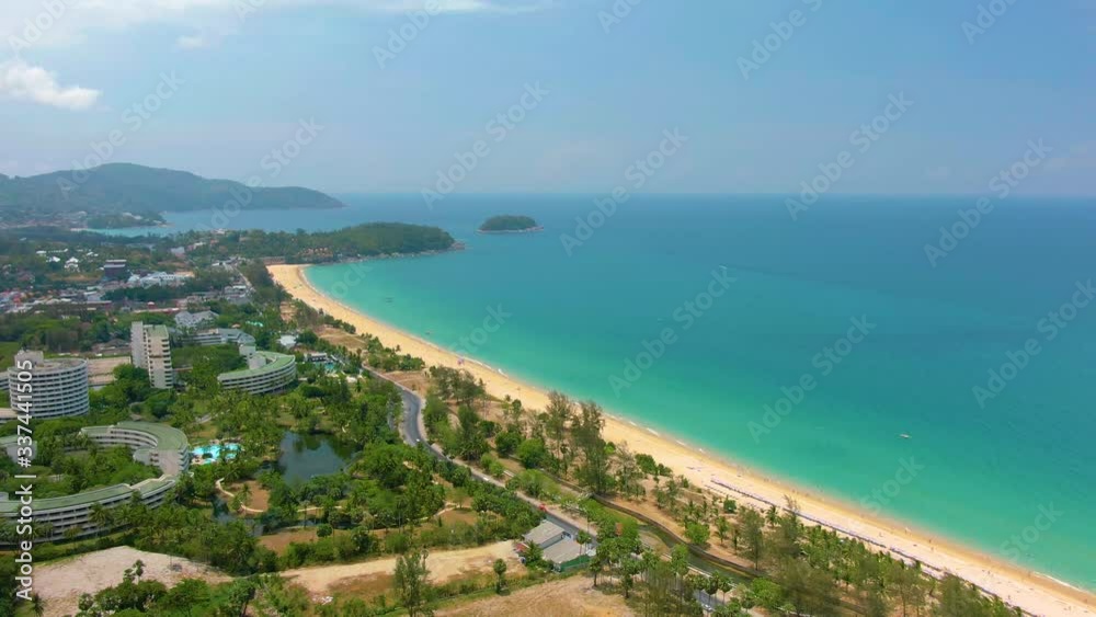 Aerial 4k view flying over tropical blue ocean towards beautiful green mountains and white sandy beach. Thailand. Phuket. Karon beach. Palms beach. Island top view. Beautiful resort place. Aerial 4k view flying over tropical blue ocean towards beautiful green mountains and white sandy beach. Thailand. Phuket. Karon beach. Palms beach. Island top view. Beautiful resort place.