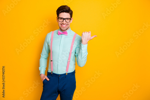 Portrait of positive guy point forefinger copyspace indicate advert promotion recommend pick tips wear blue bowtie isolated over bright shine color background © deagreez