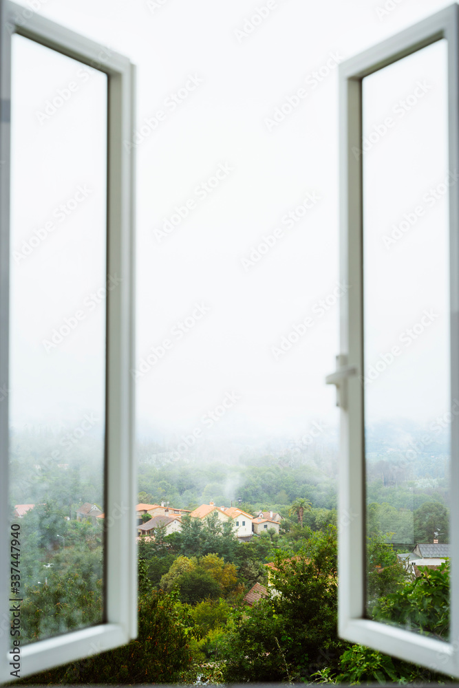 Fototapeta premium Open a window to air the room. Ventilate your house. Window with amazing countryside view on foggy day. Stay home concept. Scenery view from the house. Travel to Spain and holidays concept.
