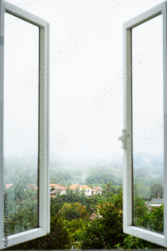 Open a window to air the room. Ventilate your house. Window with amazing countryside view on foggy day. Stay home concept. Scenery view from the house. Travel to Spain and holidays concept.