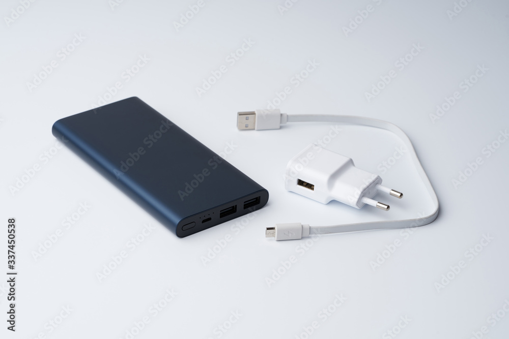 Fototapeta premium White USB power adapter, cable and blue power bank for divice isolated on a white background.