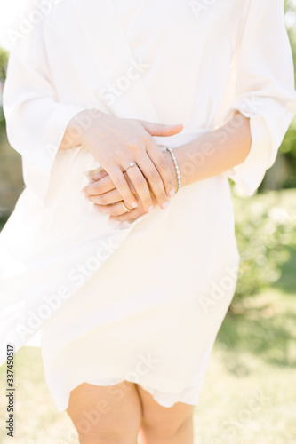 Wedding ring and bracelet. The bride poses with a dressing gown.