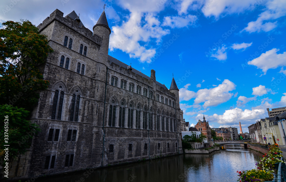 Ghent, Belgium, August 2019.Geraard de Duivelstraat Castle. The main facade overlooks the canal: it is an example of the medieval buildings of the city. Blue sky with white clouds.