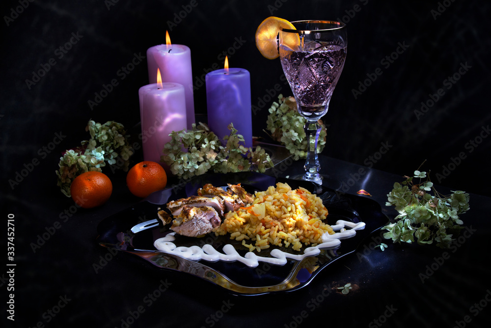 Delicious food. Beautiful glass with lemon. Festive dinner. big candles. tangerines
