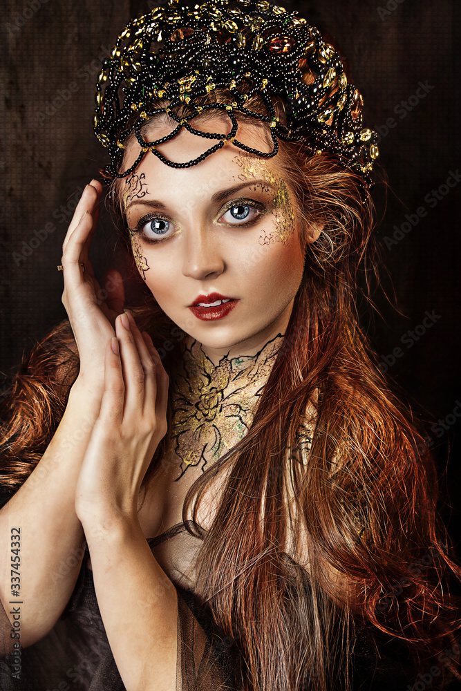 close up portrait of beautiful princess with crown and long hair. flower face painting makeup