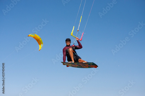 Kiteboarder or kite surfer. Man performing kitesurfing kiteboarding tricks.