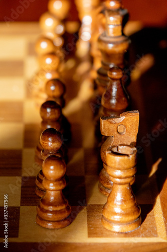 Close up image of chess board and chess pieces with lopsided sunlight and shadows