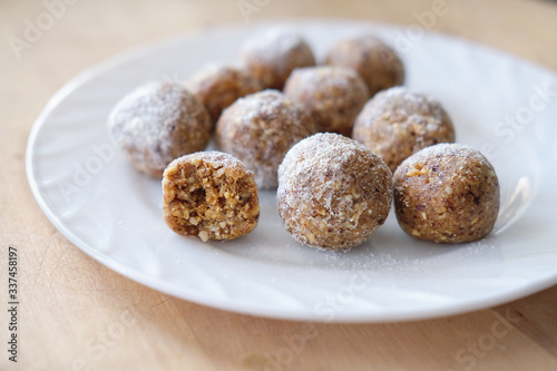 close up of protein energy balls on a plate, made of dates, collagen powder and nuts. healthy snack to take witn you. less sugar concept. © Yulia Panova
