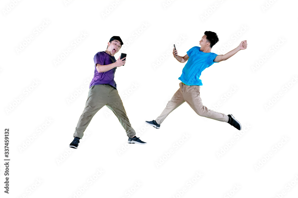 Two men jumping together with their smartphone