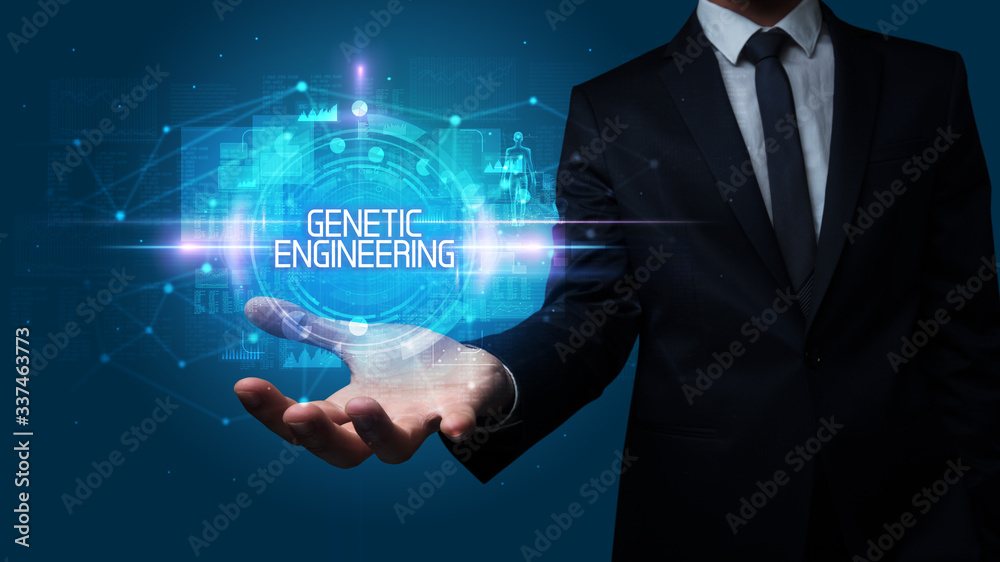 Man hand holding GENETIC ENGINEERING inscription, technology concept Man hand holding GENETIC ENGINEERING inscription, technology concept