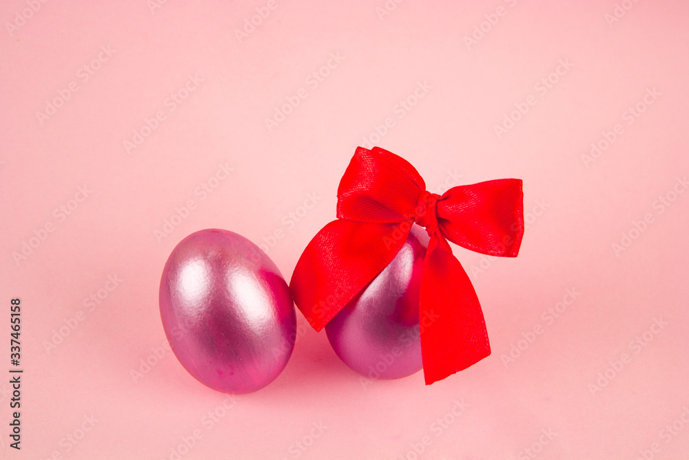 Pink Easter eggs and bright red silk ribbon bow, concept of Easter and spring holidays, festive Easter Christian traditions, place for text