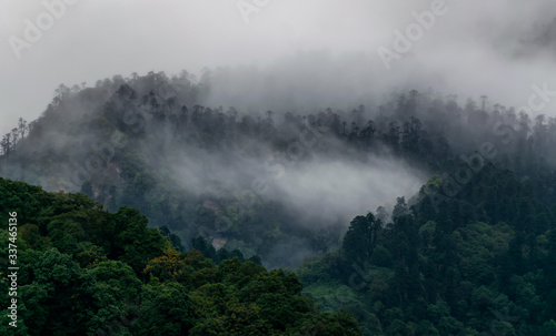 a beautiful mountain view with fog and clouds