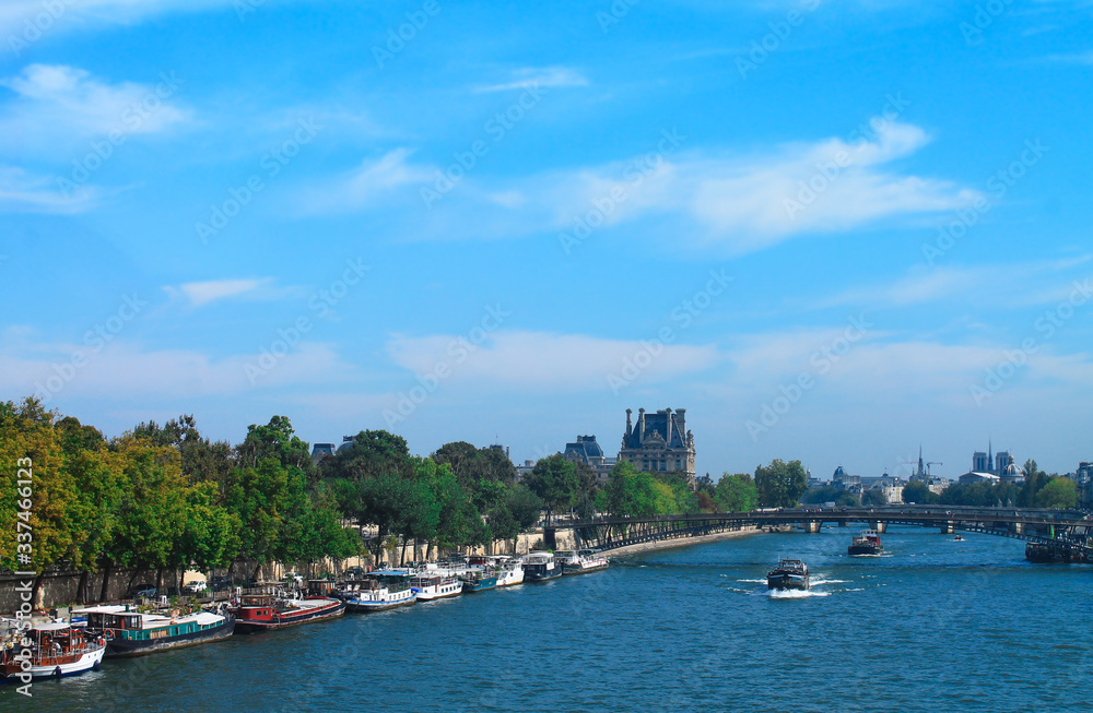 View of the Seine with ferries and a bridge in Paris in summer. France